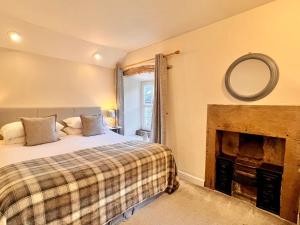 a bedroom with a bed and a fireplace at Gate Cottage in Matlock