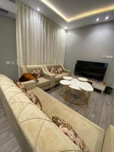a living room with two couches and a tv at شقة غرفتين وصاله دخول ذاتي in Riyadh