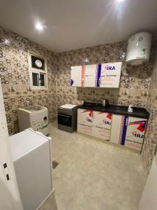 a kitchen with a white refrigerator and boxes on the wall at شقة غرفتين وصاله دخول ذاتي in Riyadh