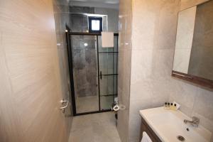 a bathroom with a shower and a sink and a mirror at Piri Reis Butik Hotel in Marmara