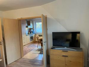 a living room with a large television and a kitchen at Fewo Kurth - Haus Dulshorn in Wildeshausen