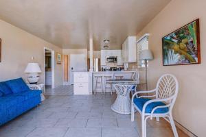 a living room with a blue couch and a kitchen at Plantation Hale Suites in Kapaa