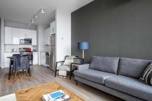 a living room with a couch and a kitchen at Loop 1BR w Deck Gym WD nr W Loop the L CHI-220 in Chicago