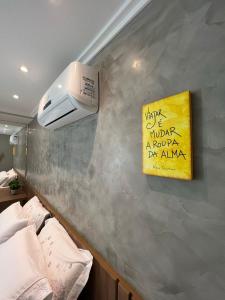 uma parede com um sinal amarelo na parede em FLAT DO BARÃO CABO BRANCO em João Pessoa