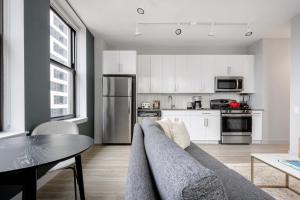 a living room with a couch and a table and a kitchen at Loop 1BR wGym Roofdeck WD nr W Loop the L CHI-200 in Chicago +24 photos