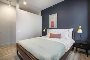 a bedroom with a large bed with a blue wall at Loop 1BR wGym Roofdeck WD nr W Loop the L CHI-200 in Chicago