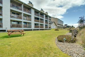 un gran edificio de apartamentos con una mesa de picnic en el patio en Ocean Shores Condo Walk to the Beach! en Ocean Shores