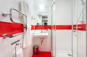 
a bathroom with a sink, toilet, and bathtub at Marins Park Hotel Yekaterinburg in Yekaterinburg
