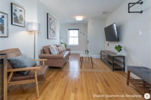 a living room with a couch and a tv at West Broadway Quarters by Thatch in Boston
