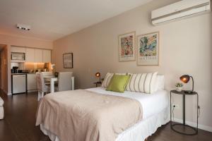 1 dormitorio con 1 cama blanca grande y cocina en Acogedor Studio Pleno Barrio de Recoleta 2C en Buenos Aires