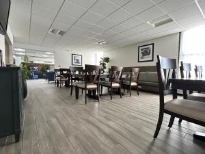 uma sala de espera com mesas e cadeiras num salão em Clarion Inn and Suites Airport em Grand Rapids