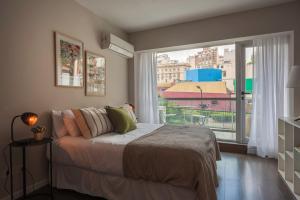 1 dormitorio con cama y ventana grande en Acogedor Studio Pleno Barrio de Recoleta 2C en Buenos Aires