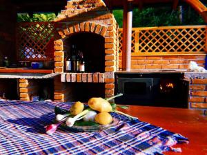 a plate of fruit on a table with a brick oven at Traditional Cottage - Vila Samovila in Delčevo