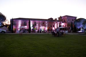 a group of people standing outside of a building with lights at Domaine de la Ruisseliere in Lacenas +73 photos