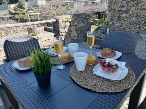 a table with food and drinks and a bowl of fruit at LA TAGORA Conect with the nature & relax in Icod de los Vinos