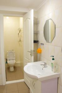 a bathroom with a sink and a toilet at Uneed Rooms Somnium in Kyiv