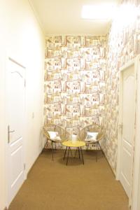 um corredor com uma mesa e cadeiras em frente a uma parede em Uneed Rooms Somnium em Kiev
