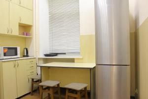 uma cozinha com um frigorífico de aço inoxidável e bancos em Uneed Rooms Somnium em Kiev