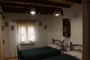 1 dormitorio con 2 camas y ventana en Casa Rural Anita en Torre Baja