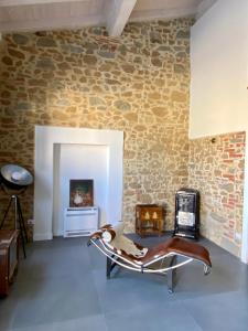 een woonkamer met een stenen muur en een bank bij Loft incantevole in Vinci