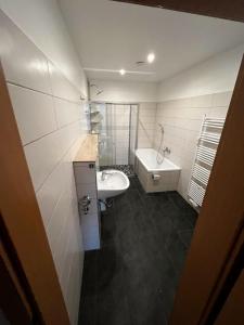 a bathroom with a sink and a toilet and a tub at Apartment für bis zu 6 Personen mit Balkon in Halberstadt