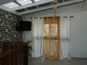 a room with a window with curtains and a television at Sweet Alar in La Estrella