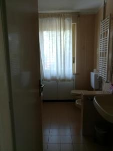 een badkamer met een toilet en een deur met een raam bij Falco Bianco in San Daniele del Friuli