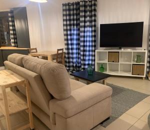 sala de estar con sofá y TV de pantalla plana en COMUNEROS82, en Baeza