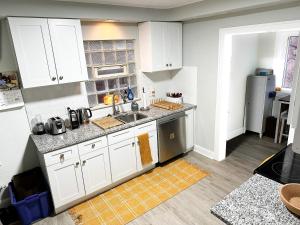 a kitchen with white cabinets and a sink at IvyLand Pines in Cleveland Heights