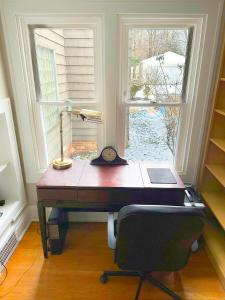 a desk with a lamp and a chair in front of a window at IvyLand Pines in Cleveland Heights