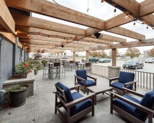 een patio met stoelen en tafels en een houten pergola bij Quality Inn in Montpelier