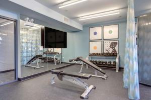 un gimnasio con cinta de correr y TV en una habitación en Logan Sq 2BR w Roof Gym 1 block to L CHI-480, en Chicago