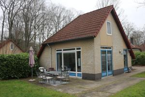 een klein huis met een tafel en stoelen bij ons Bosnest in Dalfsen