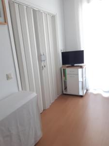 a white room with a tv and a table with a curtain at Apartaments Blau Park in L'Estartit