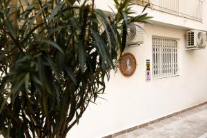 a clock on the side of a building with a plant at Apollo 3 - Luxury Apartment (City Center Studio) in Katerini