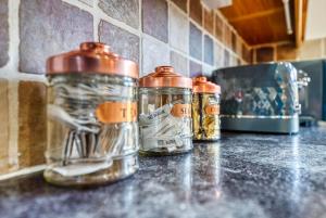 a counter top with three jars of spices on it at Safari Stays - Gated - Sleeps 14 - Hot tub - Garden in Kidderminster