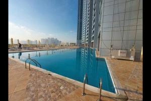 a large swimming pool on the side of a building at stunning 2-bedroom flat in Ajman 