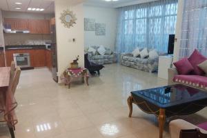 a large living room with a couch and a table at stunning 2-bedroom flat in Ajman 