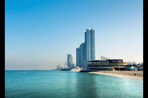 a view of a beach with buildings in the background at stunning 2-bedroom flat in Ajman 