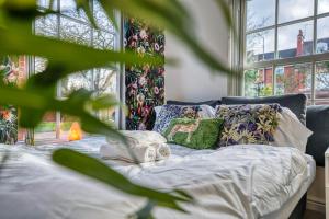 a bed with white sheets and pillows in front of a window at Safari Stays - Gated - Sleeps 14 - Hot tub - Garden in Kidderminster