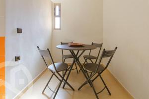 une table et quatre chaises dans une pièce dans l'établissement Chez ASSYL: résidence avec 3 piscines, à Marrakech