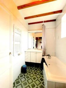 y baño con bañera, lavabo y espejo. en Maison chaleureuse proche mer en Piriac-sur-Mer