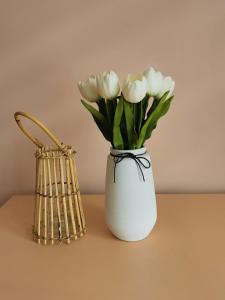 un vaso bianco pieno di fiori bianchi su un tavolo di Dabnika a Vratsa