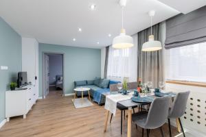 a living room with a table and a blue couch at Mint Apartments Tychy in Tychy