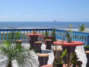 a patio with tables and chairs and the ocean at Casa na Rua da Praia com TV e Wi-fi in Pontal do Paraná