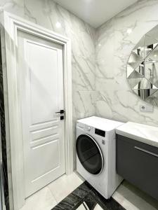 eine weiße Waschmaschine im Bad mit Waschbecken in der Unterkunft Danes23 - Self Check-in, Free Parking, Park and River View, Oldtown in Klaipėda