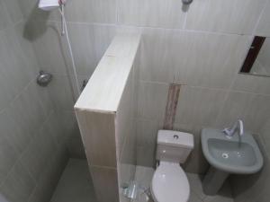 a small bathroom with a toilet and a sink at Casa na Rua da Praia com TV e Wi-fi in Pontal do Paraná