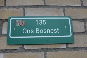 um sinal no lado de uma parede de tijolos em ons Bosnest em Dalfsen