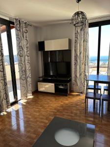 ein Wohnzimmer mit Fernseher und Tisch und Stühlen in der Unterkunft Apartamento Vacacional Gara in Adeje