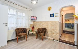 una sala de espera con 2 sillas y una mesa en Pension Mora, en Cluj-Napoca